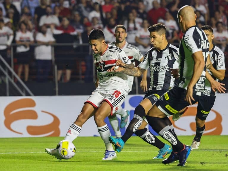 Nestor disputa a bola com jogadores do Santos no Morumbi.