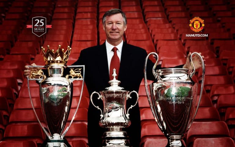 Alex Ferguson com sua tríplice coroa como um dos maiores treinadores do Manchester United.