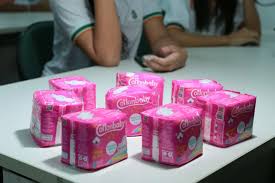 Mulher segurando absorventes - iniciativa de higiene menstrual